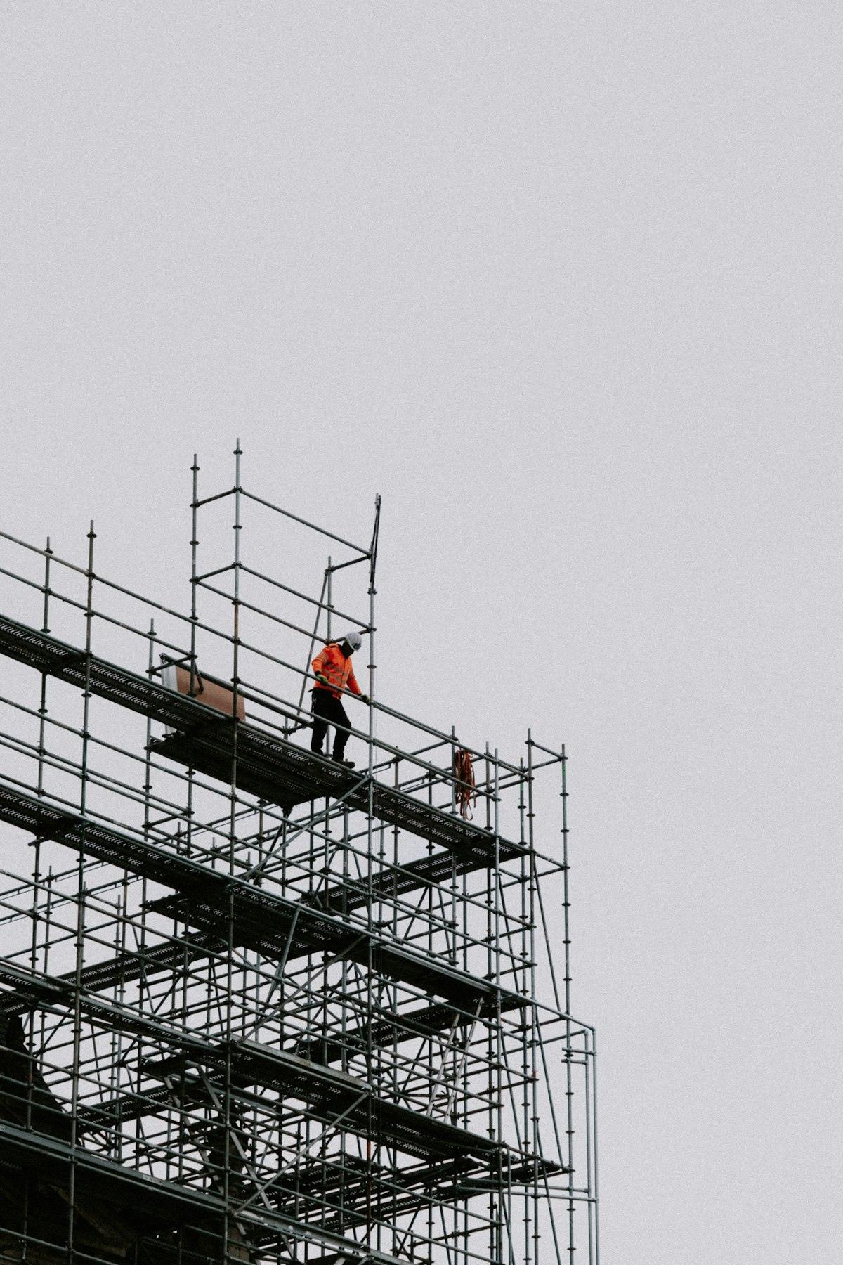 建物の上の足場で作業する職人